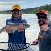 proud fly fisher with trout in drift boat