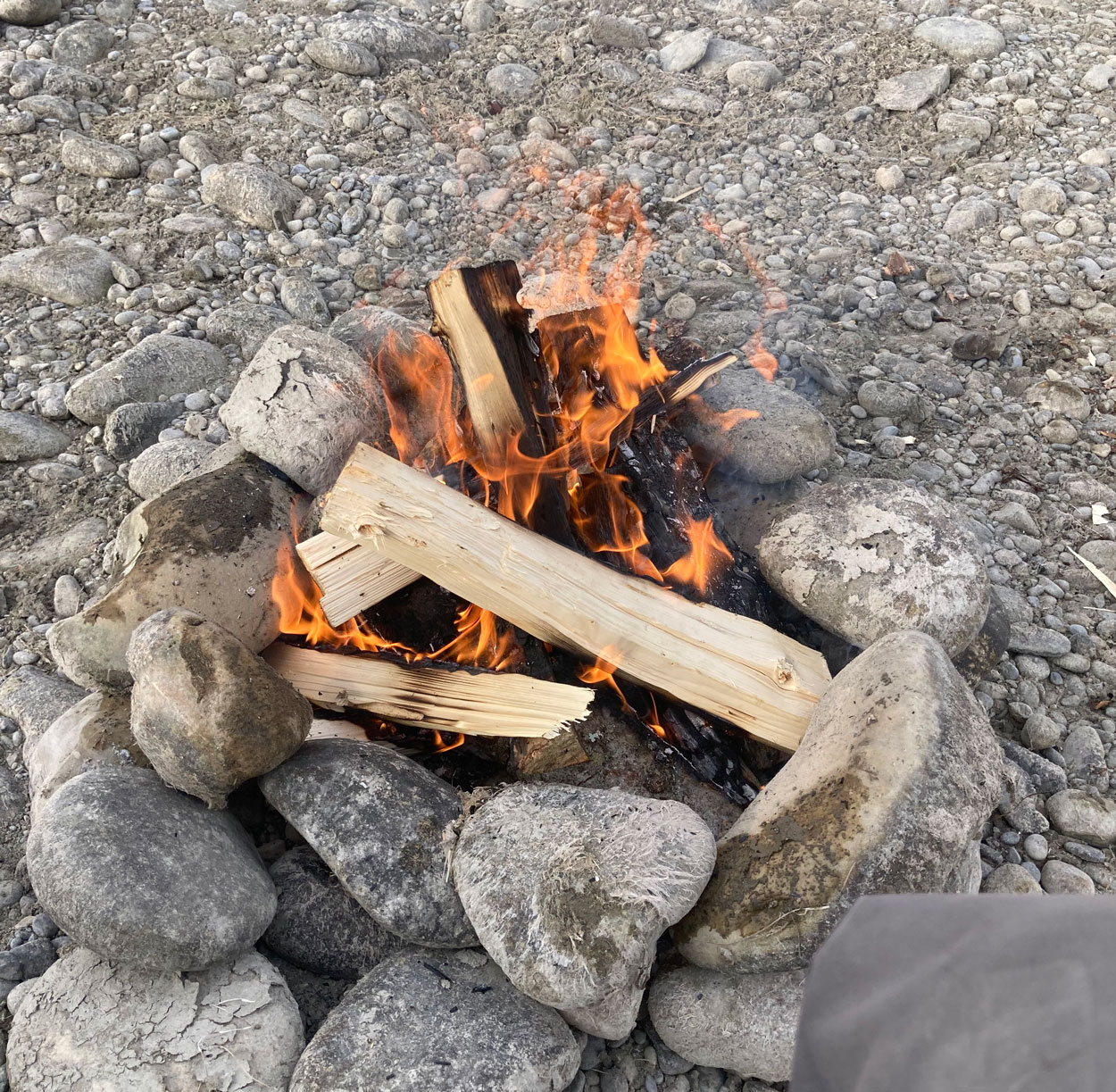 winter fishing float bow river firepit on shore to keep warm.